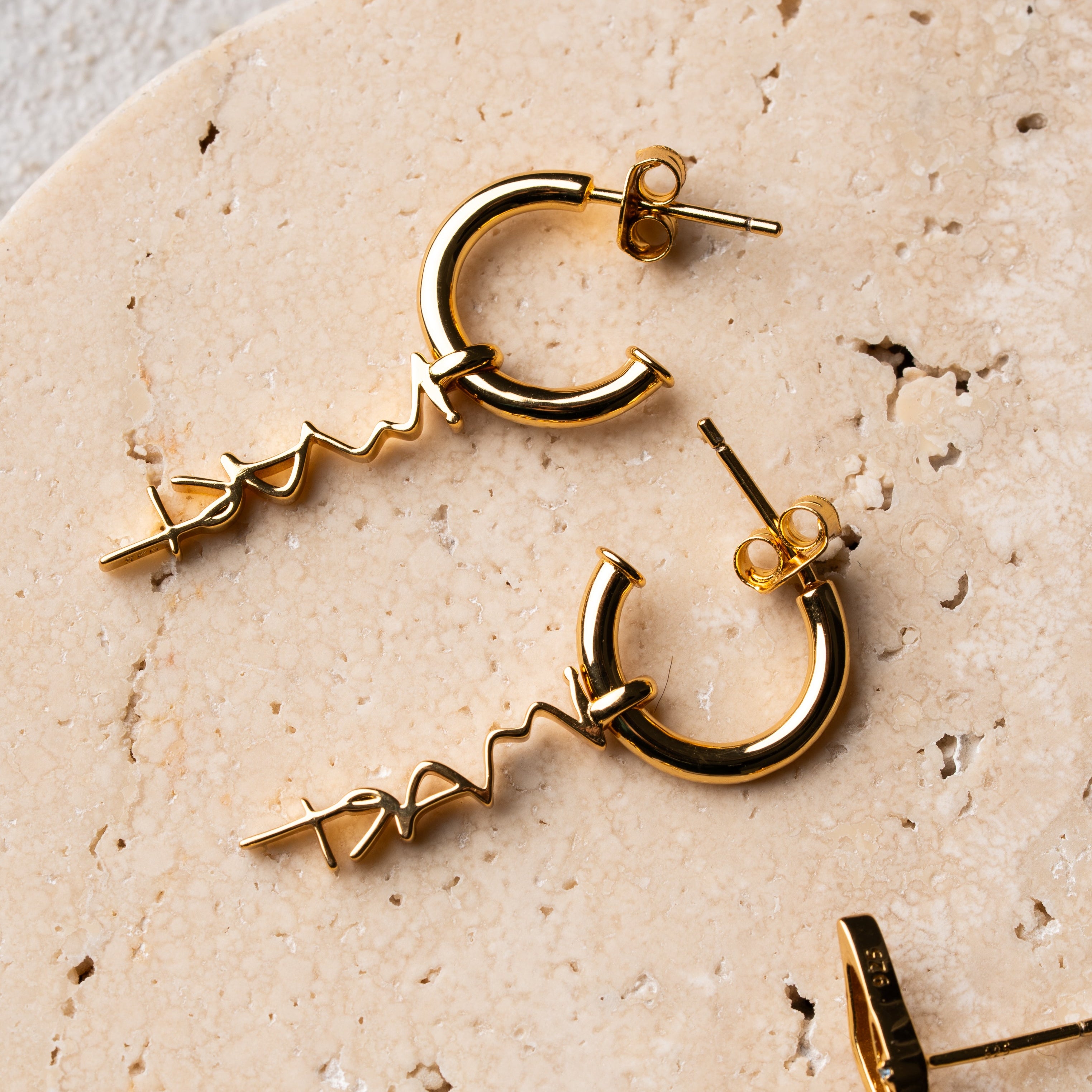 gold hoop earrings with sculptural “IM ART” charm, minimal design by AGUDO Studio